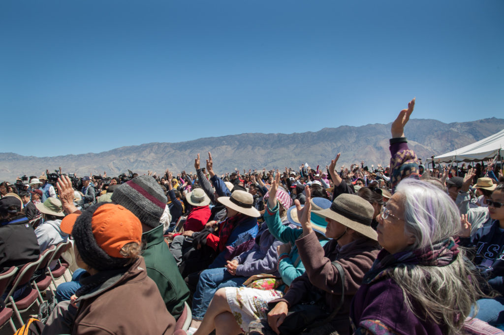 First-timers to the Manzanar Pilgrimage raise their hands. Many new people were inspired to attend this year due to similarities between the Trump administration’s rhetoric and policies against immigrants and Muslims, and the fate of Japanese-Americans during WWII. Photo by Joanne Kim