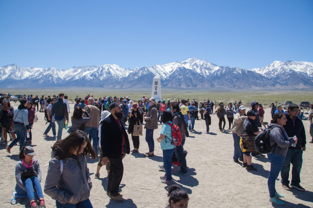 Attendees of the Manzanar Pilgrimage in the camp’s cemetery. In the middle stands “I Rei To/Soul Consoling Tower," a monument by Ryozo Kado installed in August 1943 to honor those who are buried there. Families collectively paid for its construction. Photo by Joanne Kim