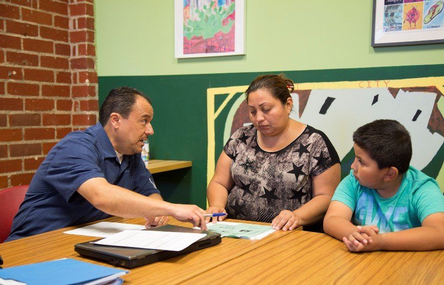 Organizing coordinator Favian Gonzalez advises a community resident at the bi-weekly Tenant Clinic at Strategic Actions for a Just Economy (SAJE).