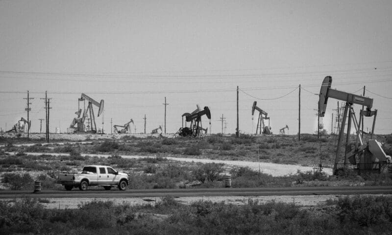 A truck drives in front of a few of the thousands of wells pulling up oil in the Loco Hills area of the Permian Basin north of Carlsbad, NM. Photo by Jerry Redfern.