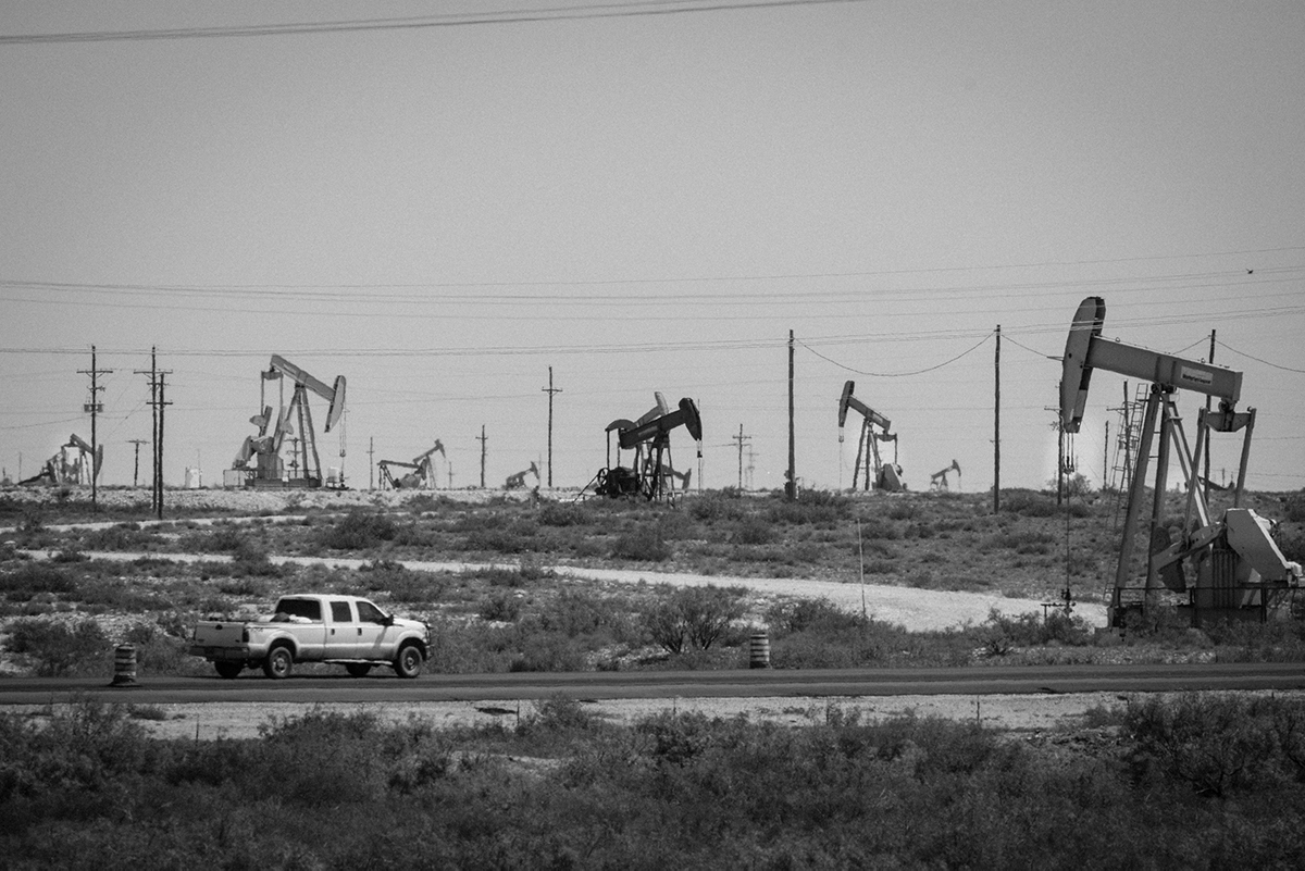 A truck drives in front of a few of the thousands of wells pulling up oil in the Loco Hills area of the Permian Basin north of Carlsbad, NM. Photo by Jerry Redfern.