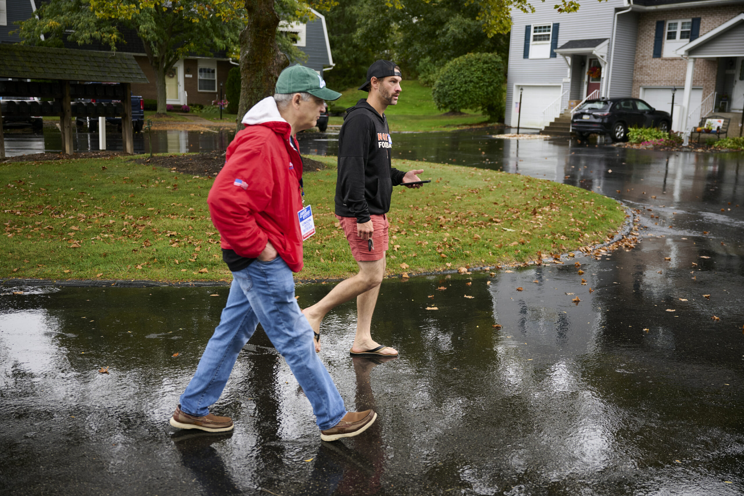Despite rain, Ryan Sanders, president of the Erie-Crawford Central Labor Council, right, and Paul Blujus canvas neighborhoods around Erie on September 28.