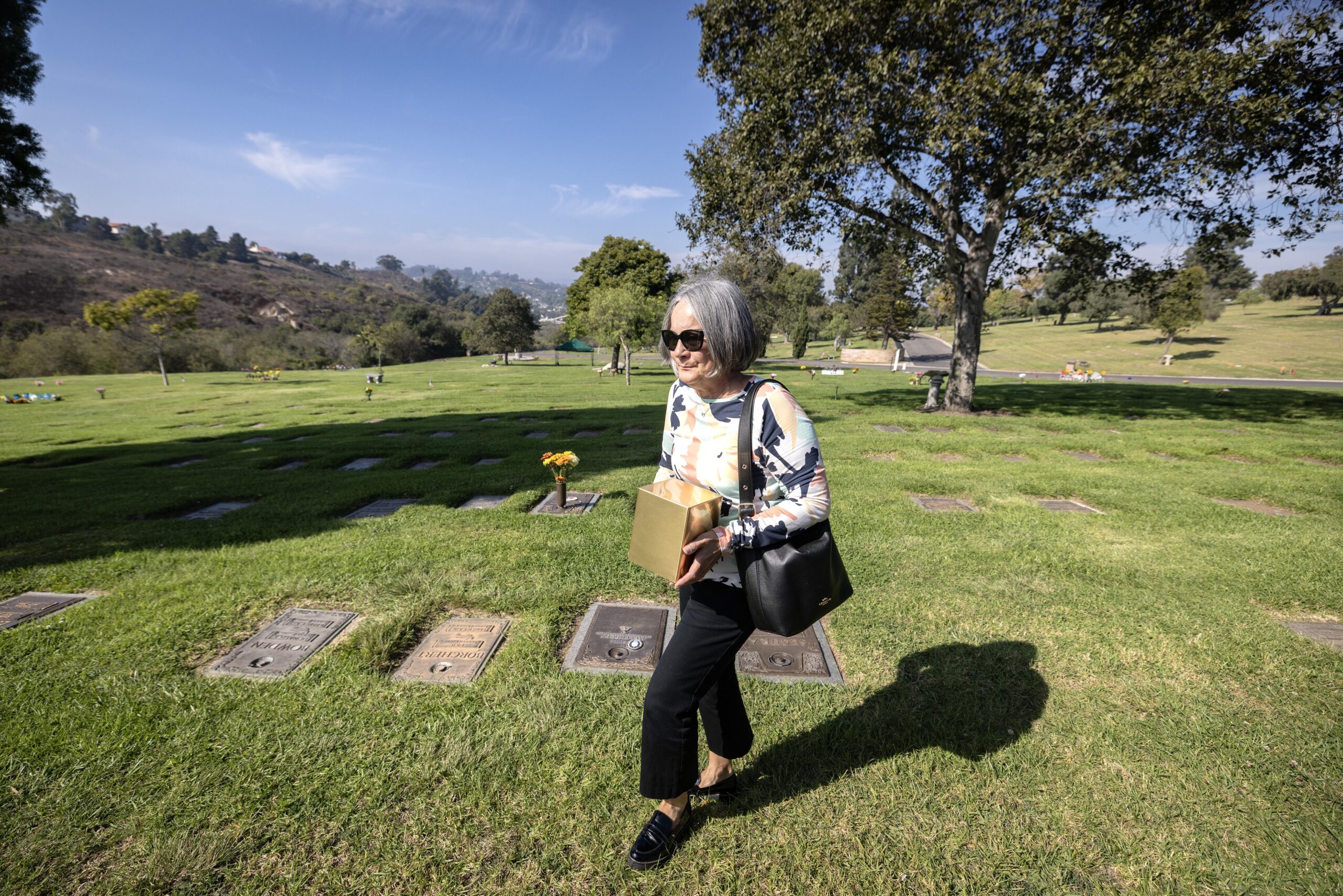 Naomi Waka carries Joanne’s ashes to her resting spot at Eternal Hills Memorial Park, a cemetery in Oceanside. Had Waka not intervened, Erickson would have been buried in a common  grave for the unclaimed dead — something Waka was determined to prevent.